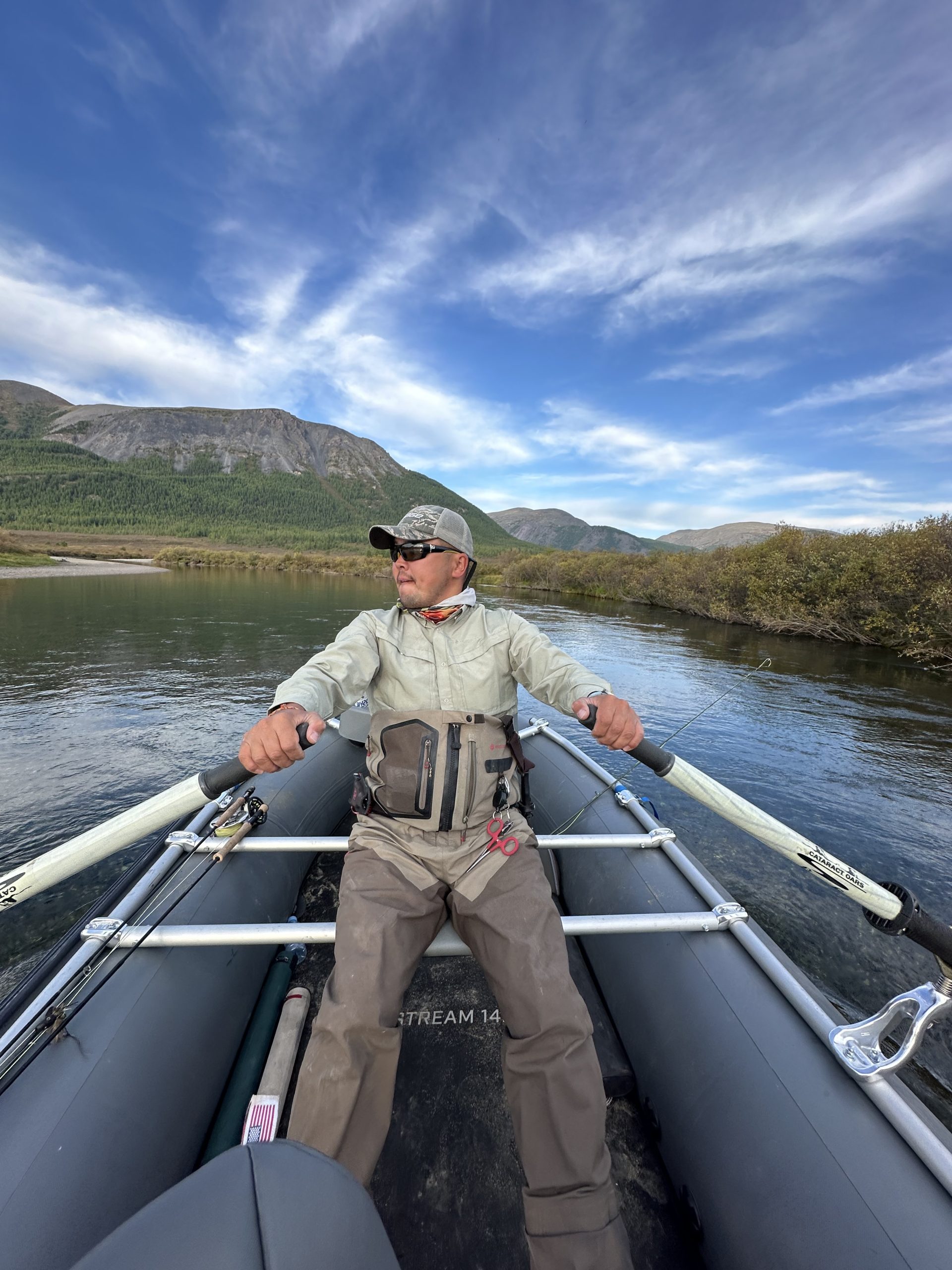 Guide rowing through a mountain valley